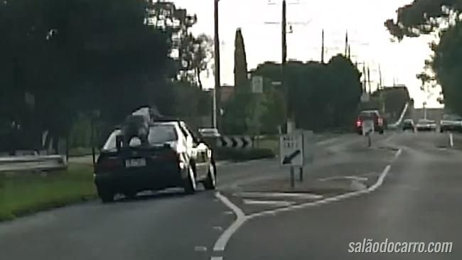 Homem aparece surfando em cima de carro em movimento
