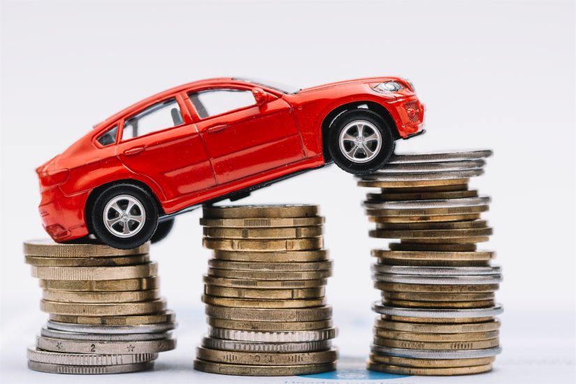Imagem de um carro em cima de grupos de 3 moedas, exibindo um grau de crescimento de preços